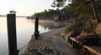 Brygga i svensk skärgård i morgonljus, populärt resmål för utländska turister
