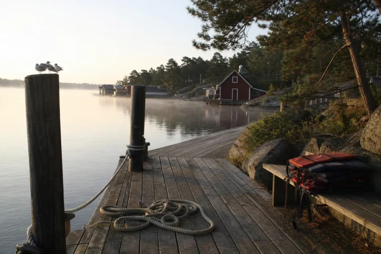 Brygga i svensk skärgård i morgonljus, populärt resmål för utländska turister